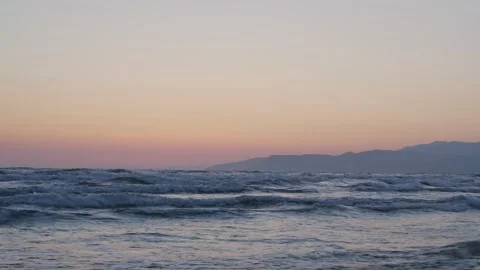 Timelapse of sea waves motion at sunset dark mountain background. Stock Footage 145086647