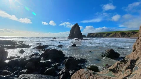 Timelapse seascape Ireland spring tides sea stack and puffy clouds in blue sky 库存影片 330896396