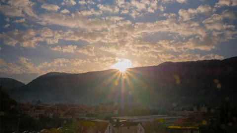 Timelapse: setting sun shining through clouds over Kotor rooftops Stock Footage 341298579