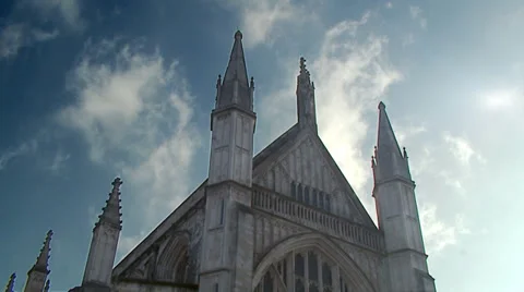 Timelapse shot of clouds moving across a blue sky against the roof of a church. Vídeo Stock 32961427