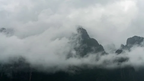 Timelapse shot of clouds surronding the cliff. Fog revealing mountain Stock Footage 112166240