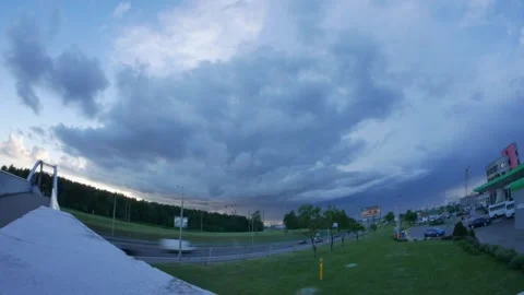 Timelapse shot of gray and dark blue clouds sailing over the city from right to Stock Footage 136732471