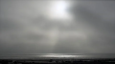 A timelapse shot of low fast moving clouds passing in front of the sun above the Video stock 57499405