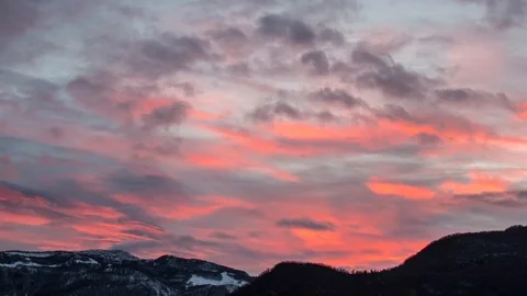 Timelapse shot of red clouds flowing on the snowy peaks at sunset, Julian Alps Stock Footage 89836148