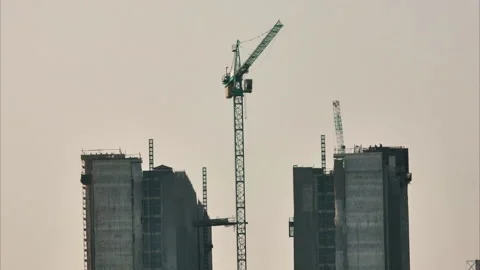 Timelapse shot of a tower crane and construction lifts bringing equipment Video stock 276106205
