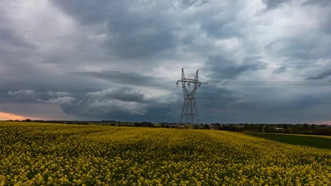 Timelapse showing moving storm clouds surrounding blooming canola fields Stock Footage 301432060