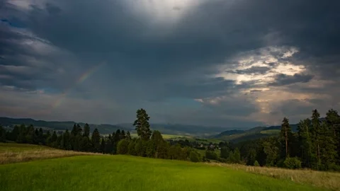 Timelapse showing a passing rain cloud with a rainbow Stock Footage 301424091