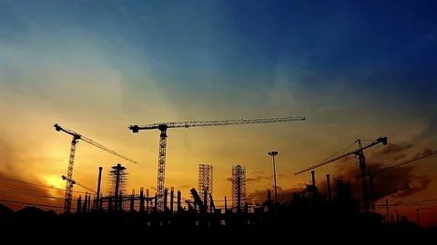 Timelapse with silhouette of cranes working on construction site on sunset sky Stock Footage