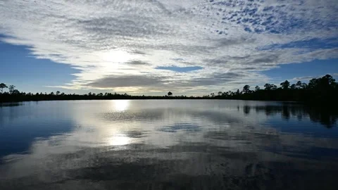 Timelapse silver gray afternoon cloudscape at Pine Glades Lake in Everglades 4K. Stock Footage 256116736
