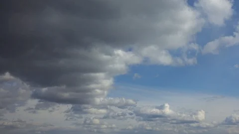 Timelapse siphoned by dramatic gray clouds against a blue sky Stock Footage 128279235