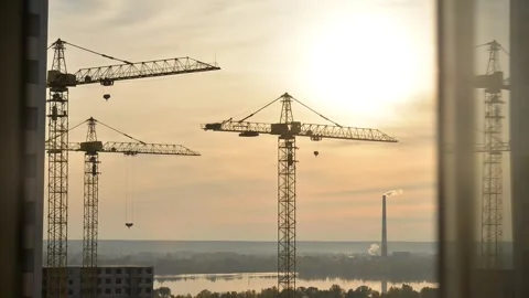 Timelapse of the sky against the background of cranes and a factory Stock Footage 144145428