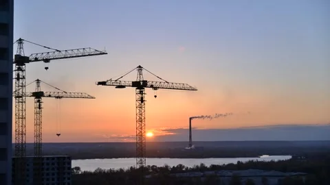 Timelapse of the sky against the background of cranes and a factory Stock Footage 144145430