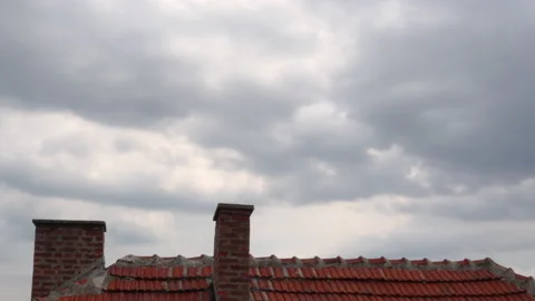Timelapse of the sky with dramatic clouds and the roof of the house on summer Stock Footage 137743997