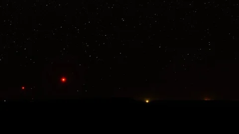 Timelapse of a sky of stars moving behind a field of wind turbines Stock Footage 101683174