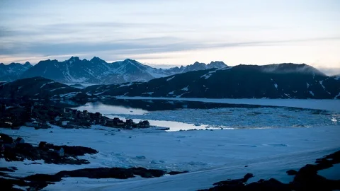 Timelapse of small iceberg pieces floating on water with snowy mountain panorama Stock Footage 121576152