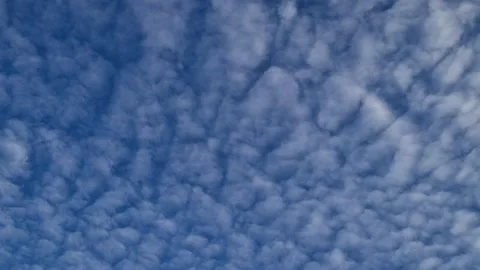 Timelapse of small symmetrical clouds drifting toward the rising sun Stock Footage 311608734