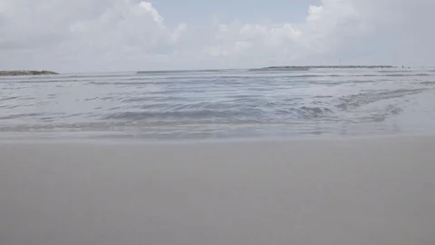Timelapse of small waves crashing on sand and feet running past Stock Footage 82829164