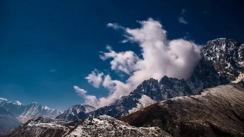 Timelapse - Spectacular clouds playing on rocky and snowy mountain ridge Stock Footage 70264640