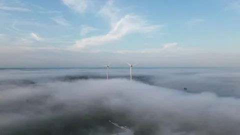 Timelapse of Spinning Wind Turbines Above Flowing Fog Video stock 320063375