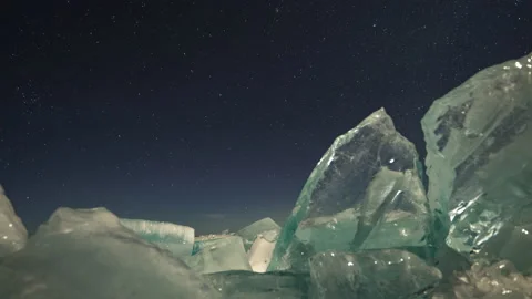 Timelapse of stars clouds sky at night. Transparent hummocks ice on foreground Stock Footage 182375264