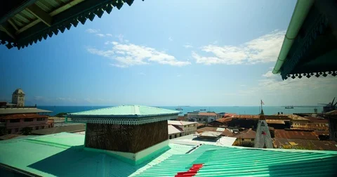 Timelapse of Stone town showing rusted roofs and ocean in the background in Stock Footage 81572052