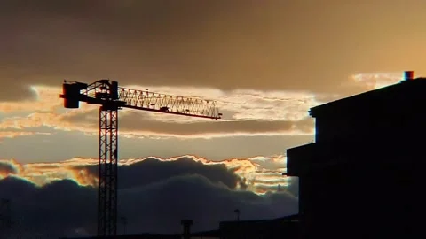Timelapse of Storm Clouds Over Construction Crane with Orange Sky Stock-Footage 332676867
