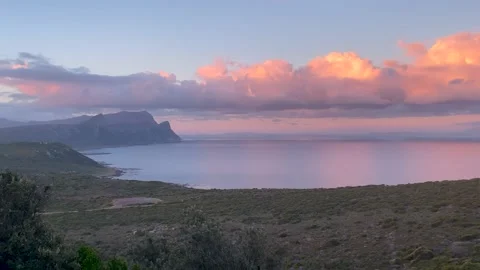 Timelapse of storm clouds rolling away from the mountains at sunset Stock Footage 168832924
