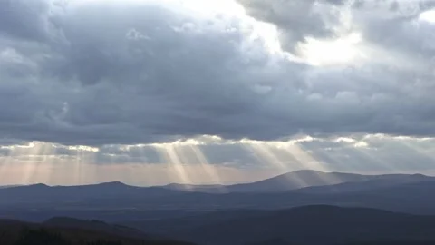 Timelapse of storm clouds through which rays of light shine on the landscape bel 스톡 동영상 273158474