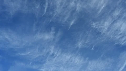Timelapse of streaky cirrus clouds moving across a bright blue summer sky Stock Footage 310215168