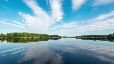 Timelapse of summer clouds reflected on calm lake Stock Footage 257340296