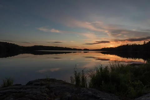 Timelapse of summer sunset reflected on calm lake Stock Footage 257340253