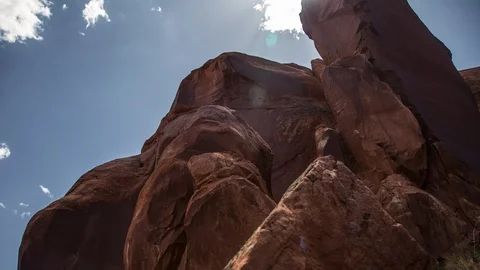Timelapse of sun and clouds behind boulders and red rocks Stock Footage 93728737