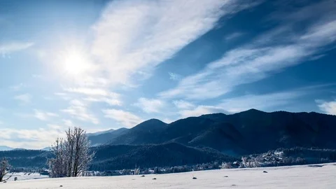 Timelapse of a sun and clouds moving through winter landscape Stock Footage