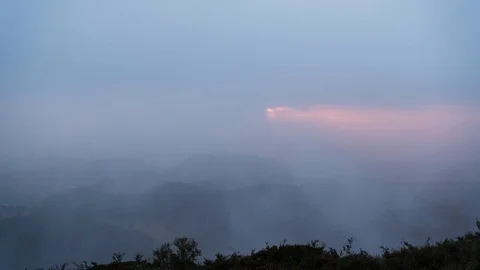 Timelapse of sun beams through mist and fog over a valley in the mountains Stock Footage 114456548