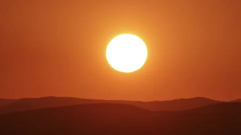 Timelapse of sun close-up rising over mountain horizon.  Stock Footage 305159704