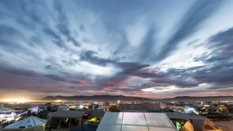 Timelapse sun fully sets over campers and tents at a desert festival 스톡 동영상 228006076