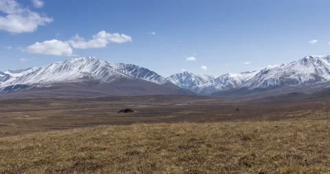 Timelapse of sun movement on crystal clear sky with clouds over snow mountain Stock Footage 155082560