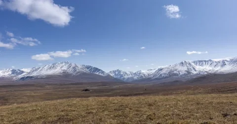 Timelapse of sun movement on crystal clear sky with clouds over snow mountain Stock Footage 234165186