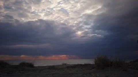 Timelapse of Sun Rays Breaking Through Dark Clouds over Ocean Horizon at Sunrise Stock Footage 345385922