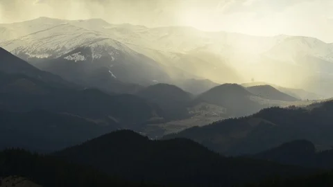 Timelapse of sun rays emerging though the dark storm clouds in the mountains Stock Footage 119523132