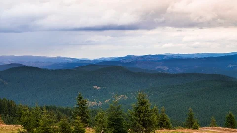 Timelapse of sun rays emerging though the dark storm clouds in the mountains Stock Footage 121814343