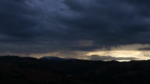 Timelapse of sun rays emerging though the dark storm clouds in the cliff Video stock 127116902