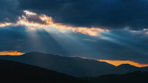 Timelapse of sun rays emerging though the dark storm clouds passing over Stock Footage 155144814