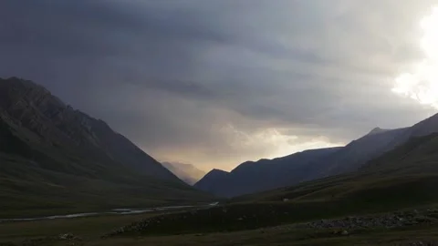 Timelapse of sun rays emerging though the dark storm clouds in the mountains Stock-Footage 168931893