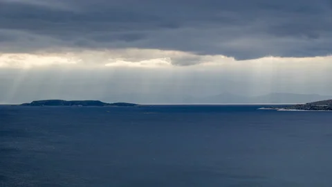 Timelapse: Sun rays shine on Aegean Sea through dark cloud Stock Footage 239827334
