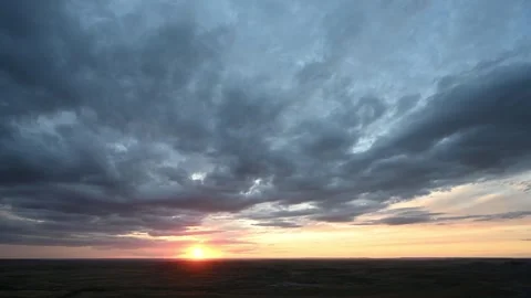 Timelapse of sun rising over a vast landscape with blue colored clouds moving Stock Footage 310898109
