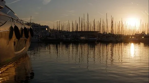 Timelapse of sun rolling behind luxury yachts silhouetted in marina Video stock 82150969