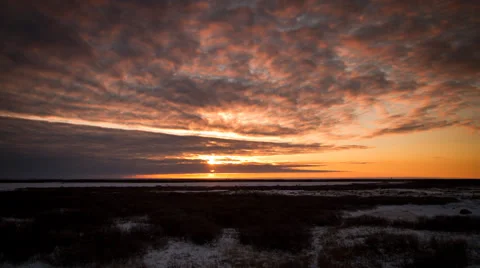 Timelapse sun setting behind clouds in orange tundra Video stock 62025772