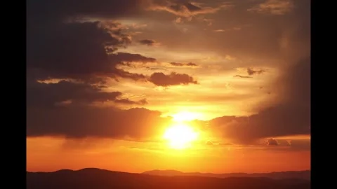 Timelapse of the sun setting behind the clouds and mountains 스톡 동영상 274710784