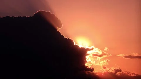 Timelapse of the sun setting behind clouds in a vibrant orange sky Stock Footage 337451665
